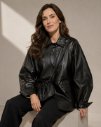 Women's Oversized Faux Leather Utility Jacket with Drawstring in Black With Bag, 03 seated or leaning, worn by model