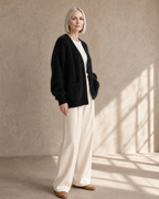Women's V-Neck Button Cardigan with Pockets in Black, three-quarter turn, worn by model