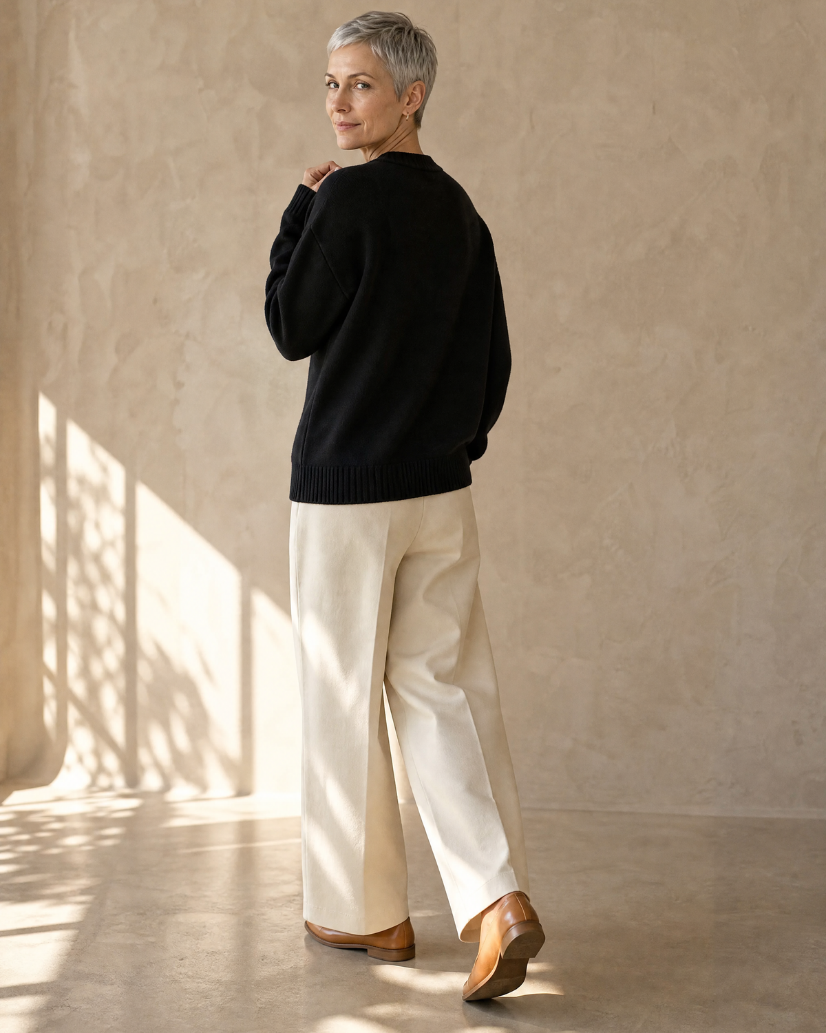 Women's Relaxed Fish Motif Knit Sweater in Black, walking away, glance back, worn by model