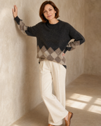 Women's Colour Block Argyle Knit Sweater in Dark Gray, forearm on wall, worn by model