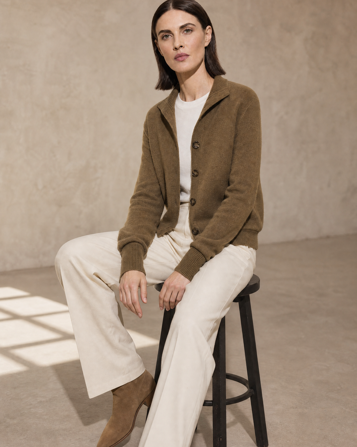 Women's Stand Collar Button Front Cardigan in Deep Camel Color, stool, forearms on thighs, worn by model