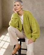 Women's V-Neck Button Cardigan with Pockets in Matcha green, stool, elbow on knee, worn by model
