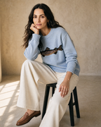 Women's Relaxed Fish Motif Knit Sweater in Blue, stool, elbow on knee, worn by model