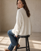 Women's V-Neck Button Cardigan with Pockets in White, stool, back turned, worn by model