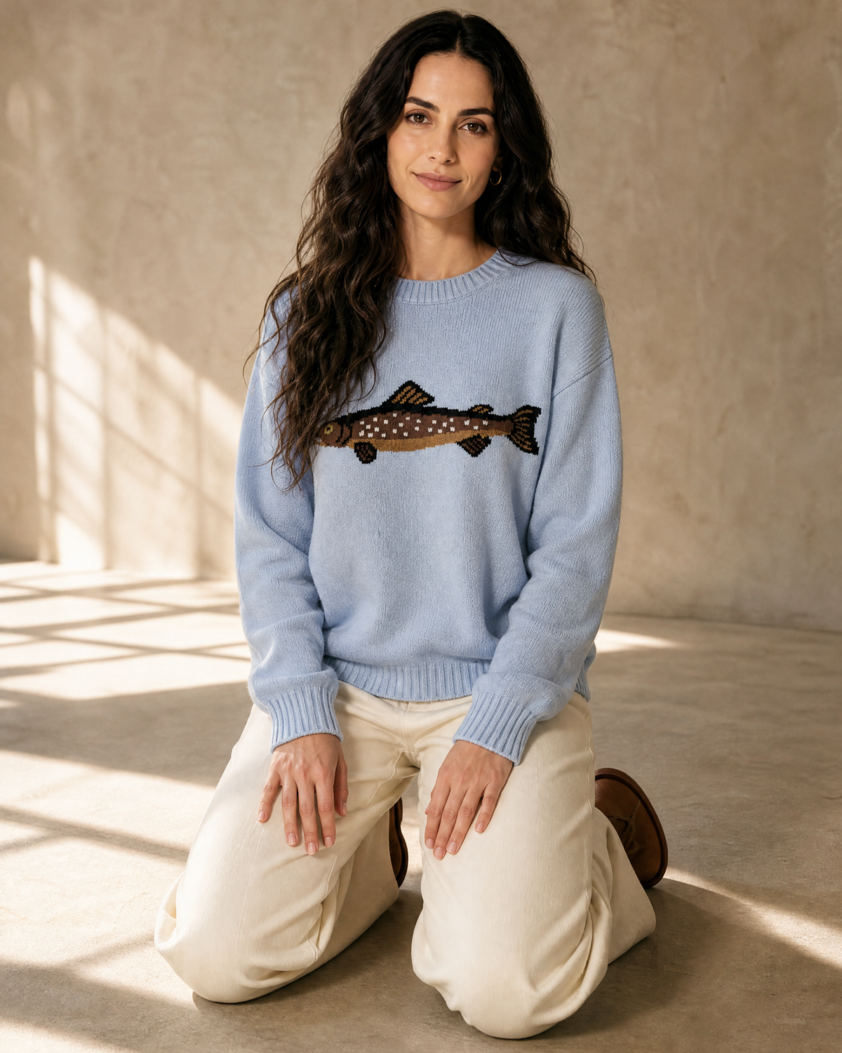 Women's Relaxed Fish Motif Knit Sweater in Blue, kneeling upright, worn by model