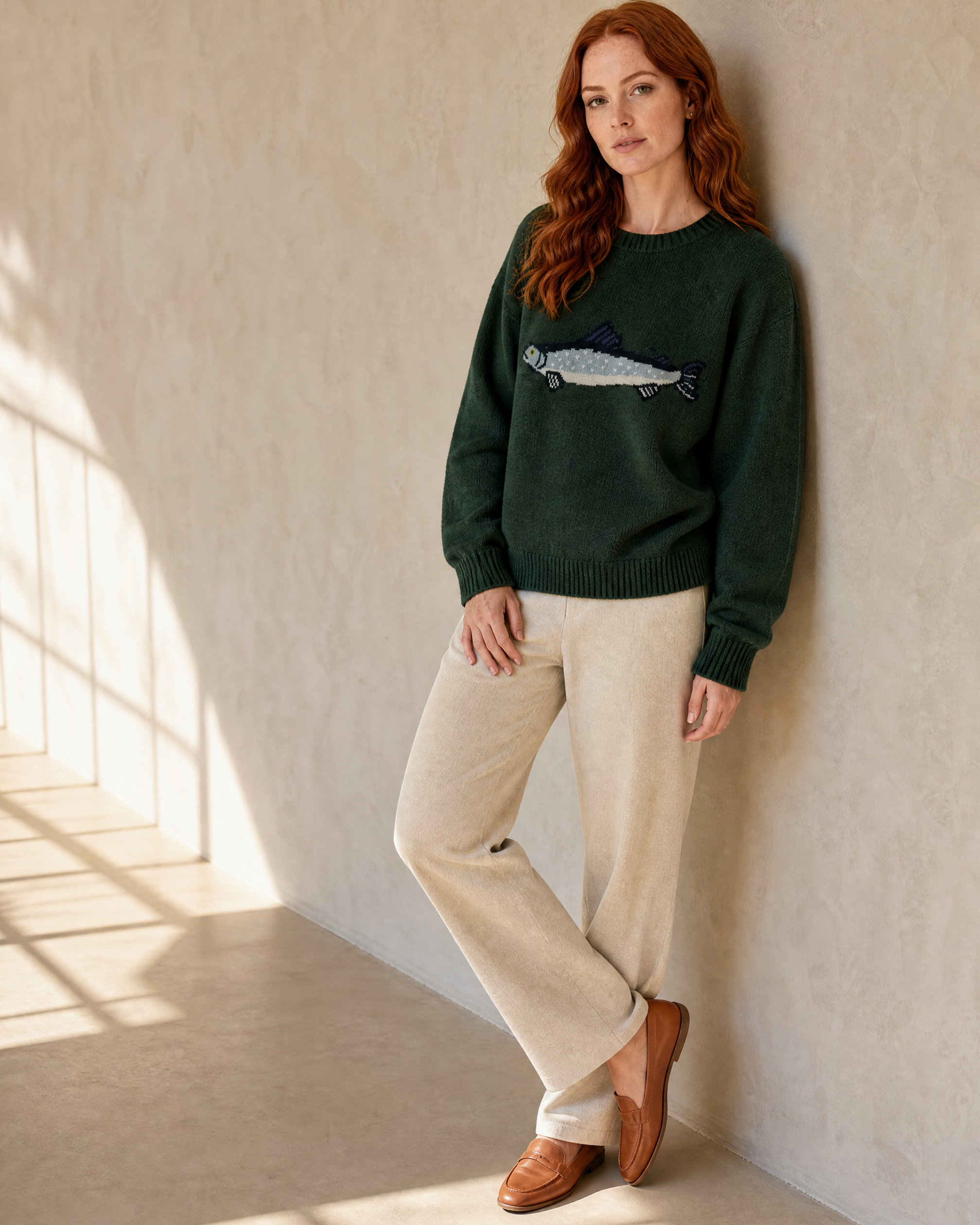 Women's Relaxed Fish Motif Knit Sweater in Dark Green, hip to wall, half profile, worn by model