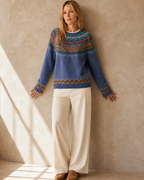 Women's Multicolour Patterned Crew Neck Sweater in Blue, back against wall, head turned, worn by model