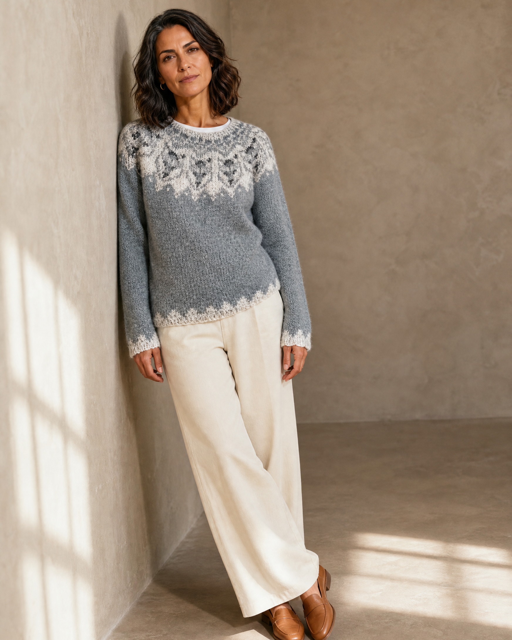 Women's Multicolour Patterned Crew Neck Sweater in Tibetan Wolf, shoulder blade to wall, ankles crossed, worn by model