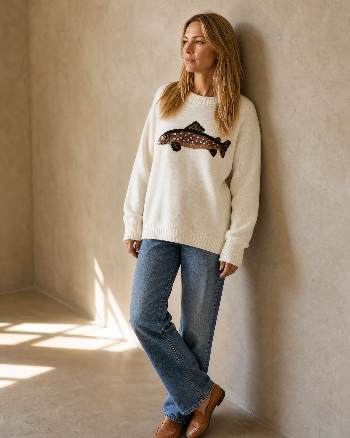 Women's Relaxed Fish Motif Knit Sweater in White, wall lean, looking to the light, worn by model