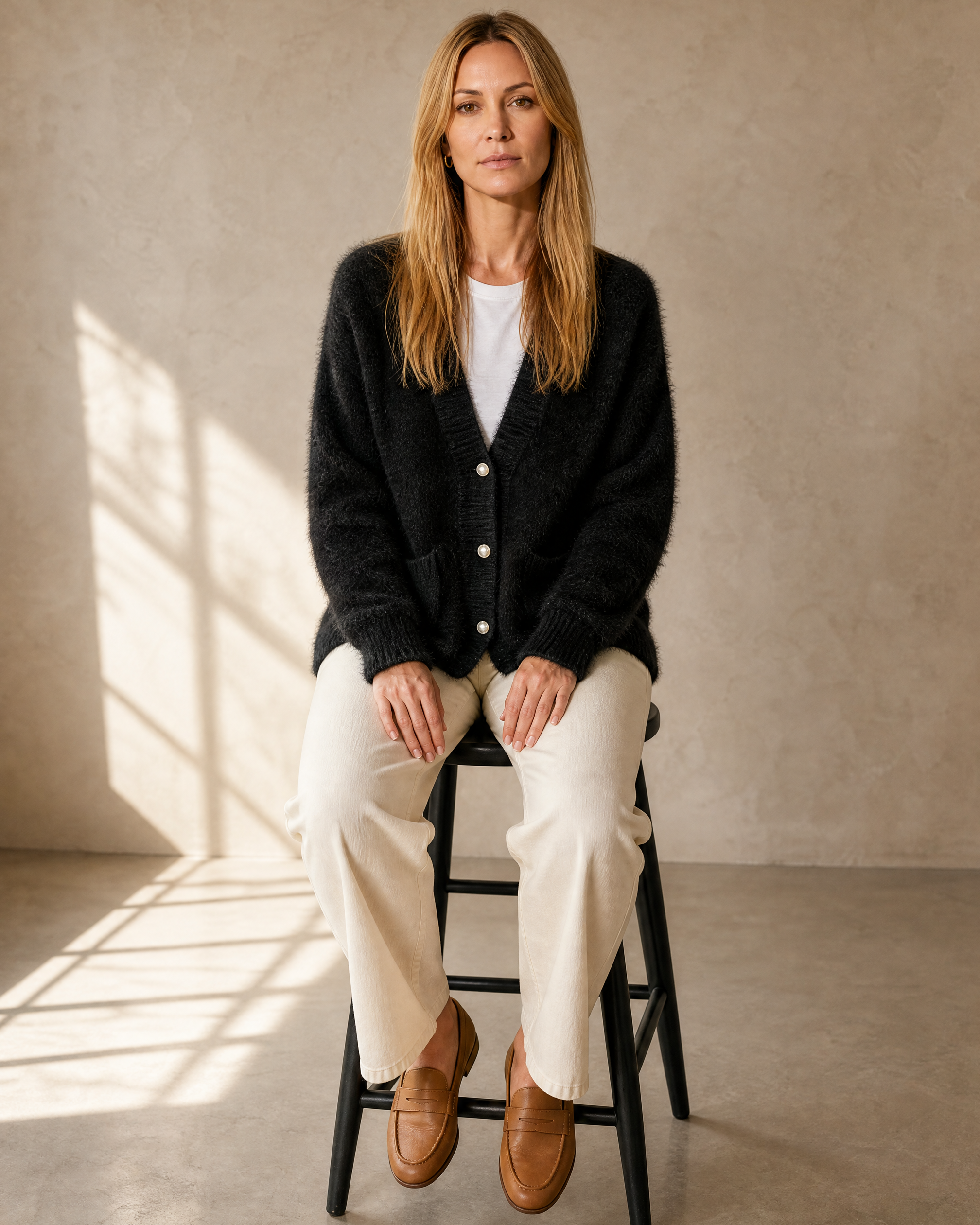 Women's Fuzzy Button Cardigan with Patch Pockets in Black, stool, both feet on rung, worn by model