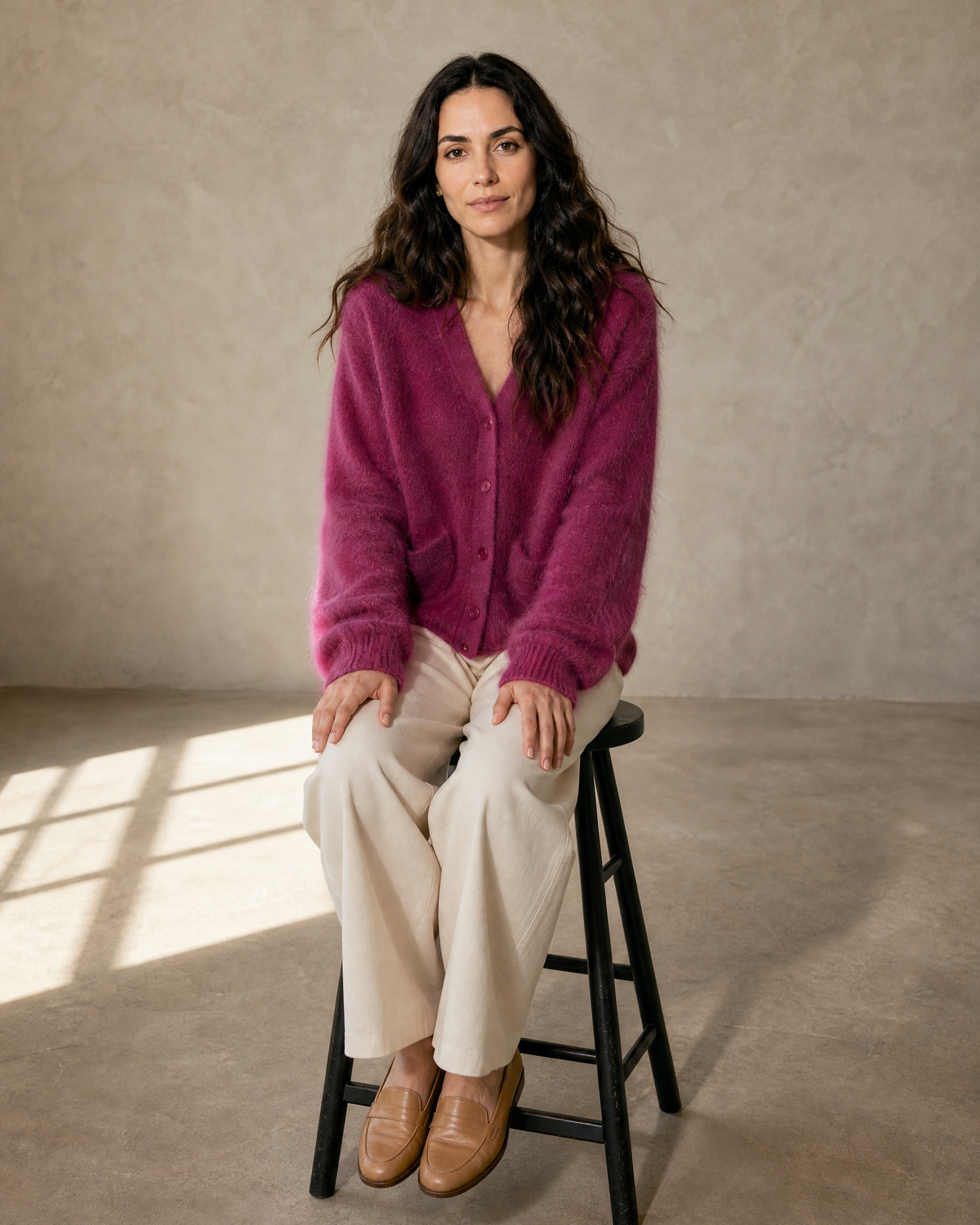 Women's V-Neck Button Cardigan with Pockets in Dark Violet, stool, both feet on rung, worn by model