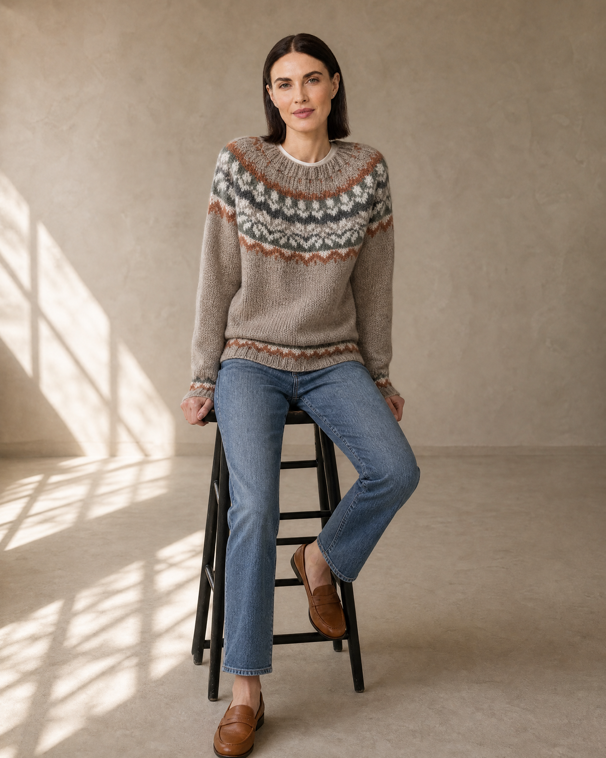 Women's Multicolour Patterned Crew Neck Sweater in Camel, stool, leaning back on hands, worn by model