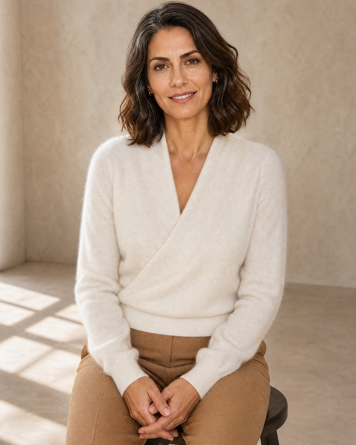 Women's Wrap V-Neck Knit Sweater for Everyday Layering in Milk white, stool, hands in lap, worn by model