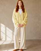 Women's V-Neck Button Cardigan with Pockets in Yellow, standing, hands softly clasped, worn by model