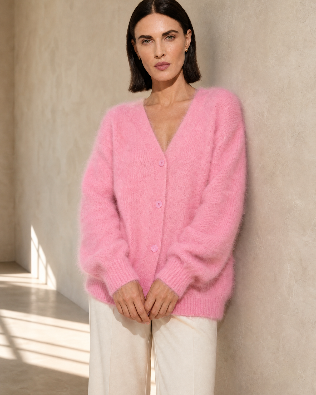 Women's V-Neck Button Cardigan with Pockets in Pink, wall lean, hands loosely joined, worn by model