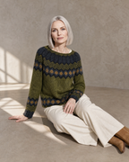 Women's Multicolour Patterned Crew Neck Sweater in Green, floor, legs extended to one side, worn by model