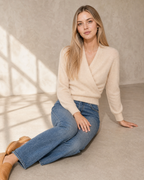 Women's Wrap V-Neck Knit Sweater for Everyday Layering in Vanilla beige, floor, legs extended to one side, worn by model