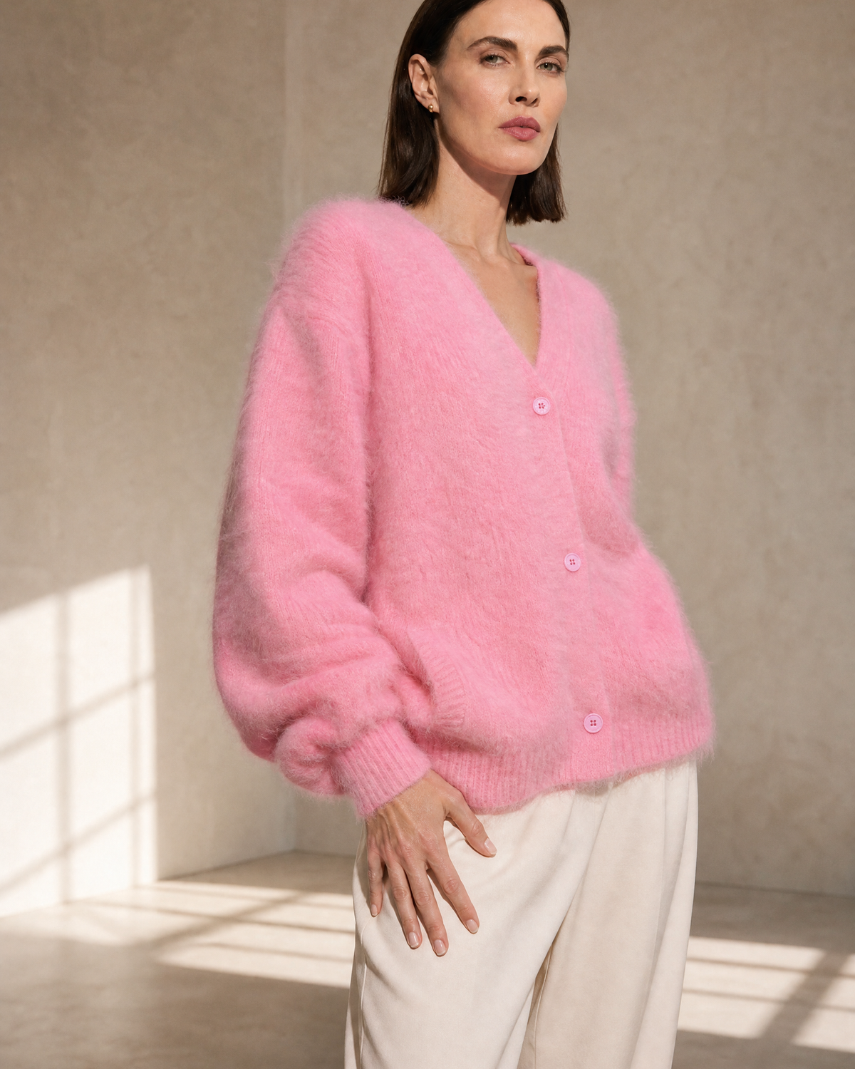 Women's V-Neck Button Cardigan with Pockets in Pink, hem and side seam detail, worn by model
